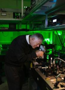 Robert Byer uses an infrared viewing device to check the alignment of a near-IR laser through a linear crystal. Image credit Misha Bruk